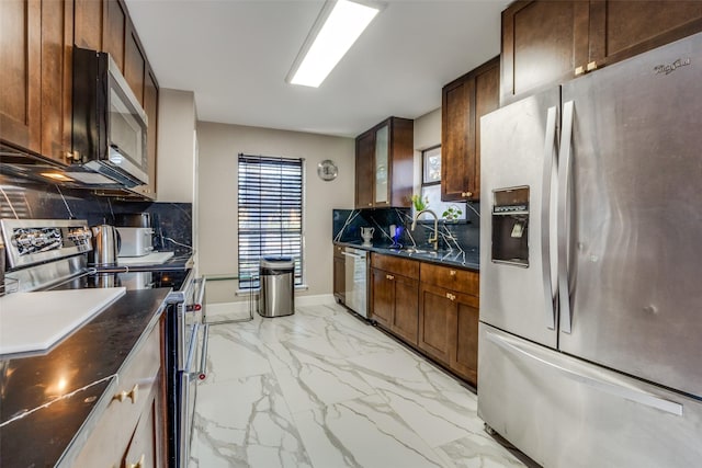 kitchen with decorative backsplash, appliances with stainless steel finishes, and sink