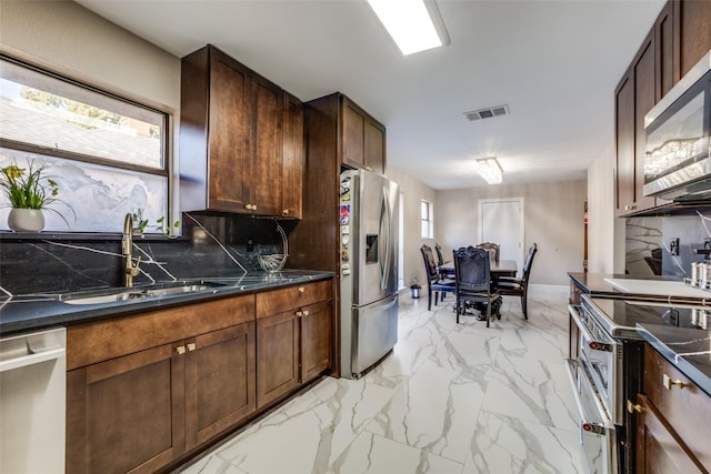 kitchen with tasteful backsplash, sink, a healthy amount of sunlight, and appliances with stainless steel finishes