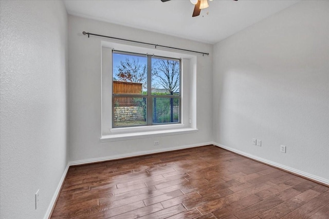 unfurnished room with ceiling fan and dark hardwood / wood-style flooring