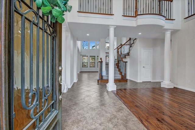 entrance foyer with tile patterned flooring, a high ceiling, and decorative columns