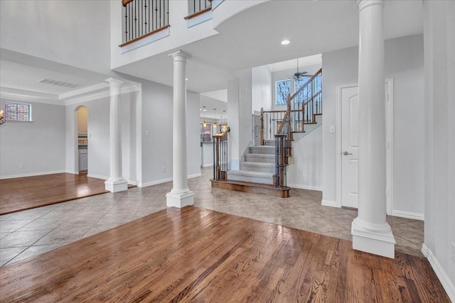 entrance foyer with light wood-type flooring, ornate columns, and ceiling fan