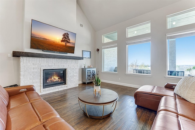 living room featuring dark wood-type flooring, high vaulted ceiling, and a fireplace