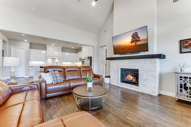 living room with dark wood-type flooring, a brick fireplace, and high vaulted ceiling