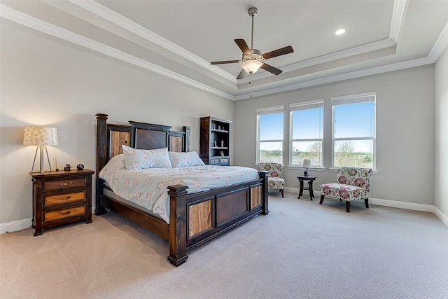 bedroom featuring ceiling fan, ornamental molding, light carpet, and a tray ceiling