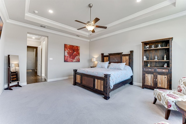 carpeted bedroom featuring a raised ceiling, ceiling fan, and ornamental molding