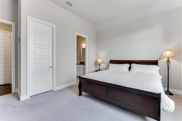 carpeted bedroom with connected bathroom and vaulted ceiling