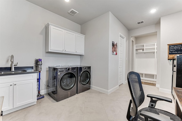 washroom featuring sink, cabinets, and separate washer and dryer