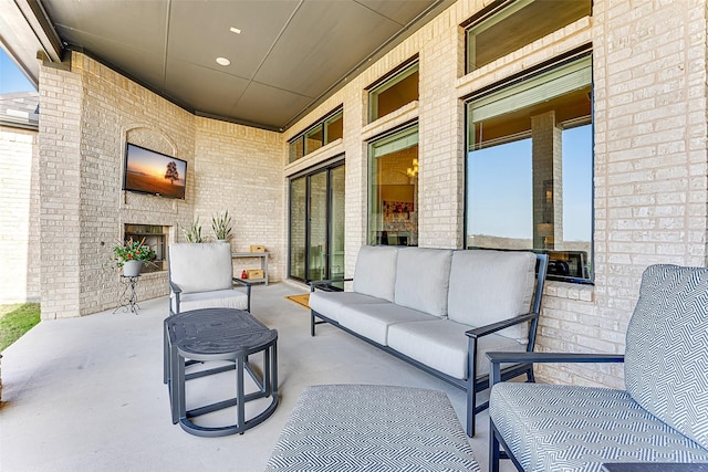 view of patio with an outdoor living space with a fireplace