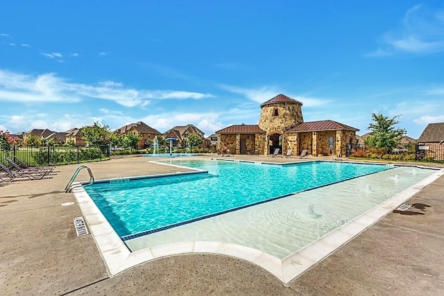 view of swimming pool with pool water feature and a patio area