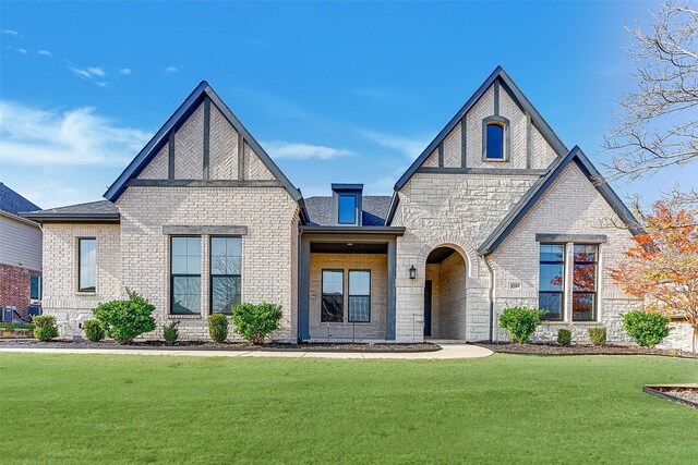 english style home featuring a front yard