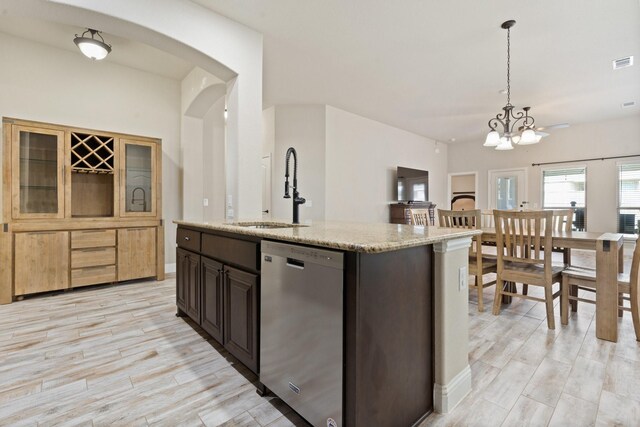 kitchen featuring dark brown cabinets, decorative light fixtures, stainless steel dishwasher, and sink