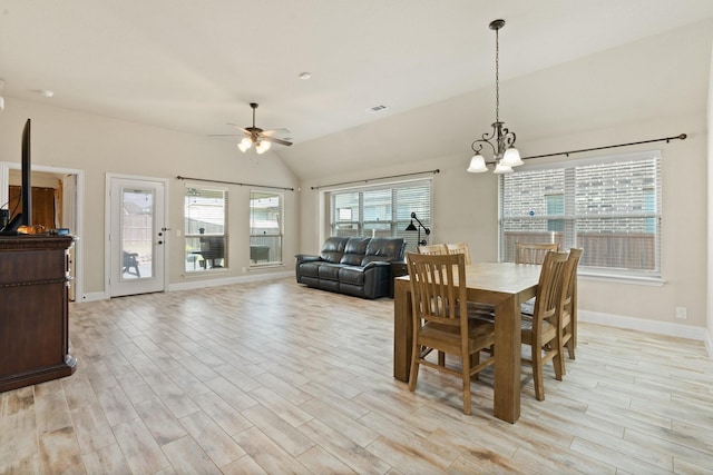 dining room with lofted ceiling, ceiling fan with notable chandelier, and light hardwood / wood-style floors