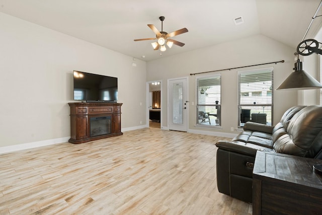 living room with ceiling fan, lofted ceiling, and light wood-type flooring