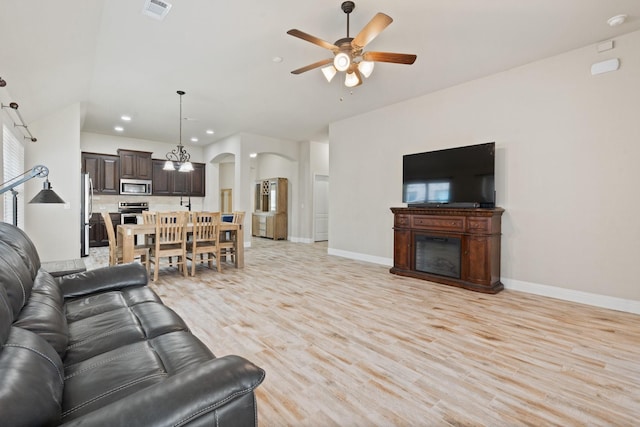 living room featuring ceiling fan and light wood-type flooring