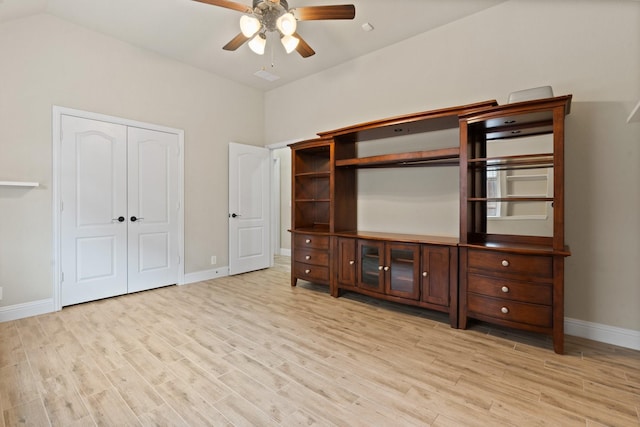 unfurnished bedroom featuring ceiling fan, lofted ceiling, light wood-type flooring, and a closet