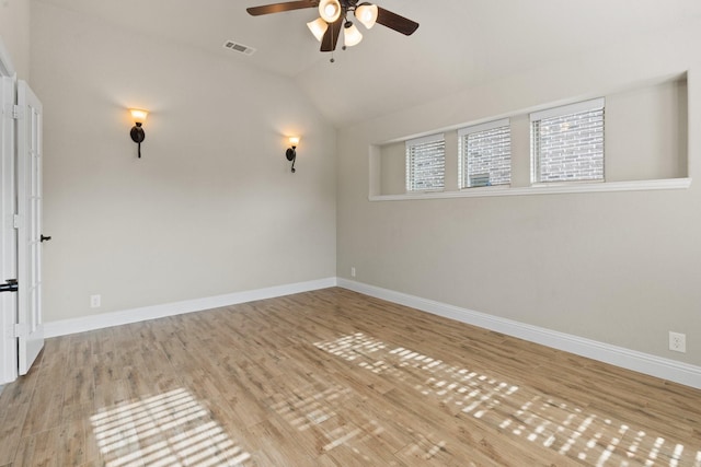 empty room with vaulted ceiling, ceiling fan, and light hardwood / wood-style flooring