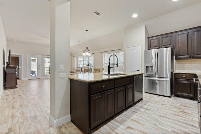 kitchen featuring sink, decorative backsplash, decorative light fixtures, light hardwood / wood-style floors, and stainless steel appliances