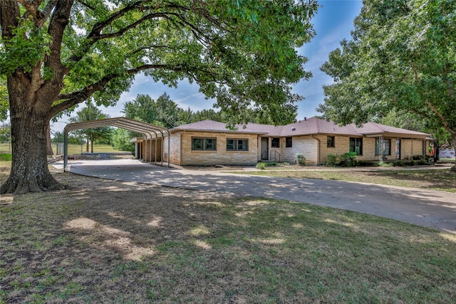 single story home with a front yard and a carport