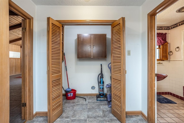 hall featuring a textured ceiling and tile patterned floors