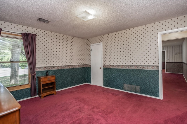 carpeted spare room featuring a textured ceiling