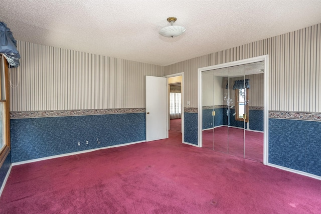 unfurnished room featuring carpet and a textured ceiling