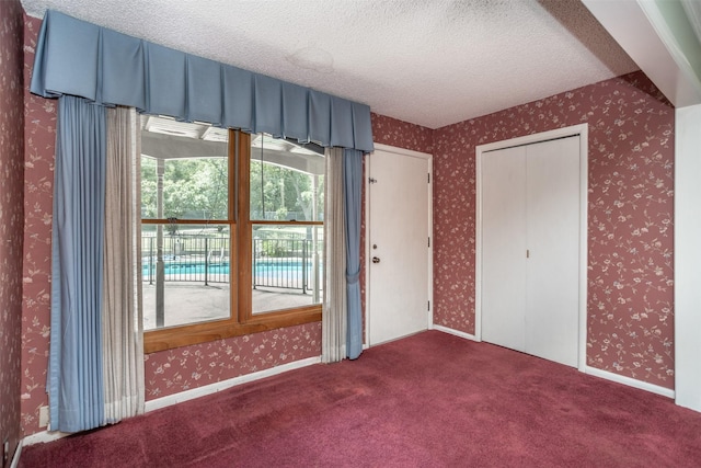 unfurnished bedroom with a closet, carpet, and a textured ceiling