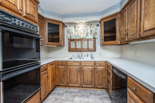 kitchen with black appliances, sink, and a textured ceiling