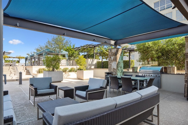 view of patio / terrace with grilling area, an outdoor hangout area, and an outdoor kitchen