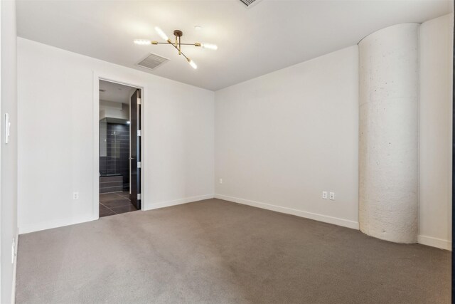 carpeted spare room featuring a chandelier