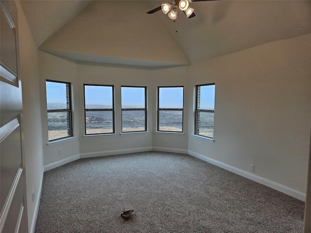 carpeted empty room with ceiling fan and high vaulted ceiling