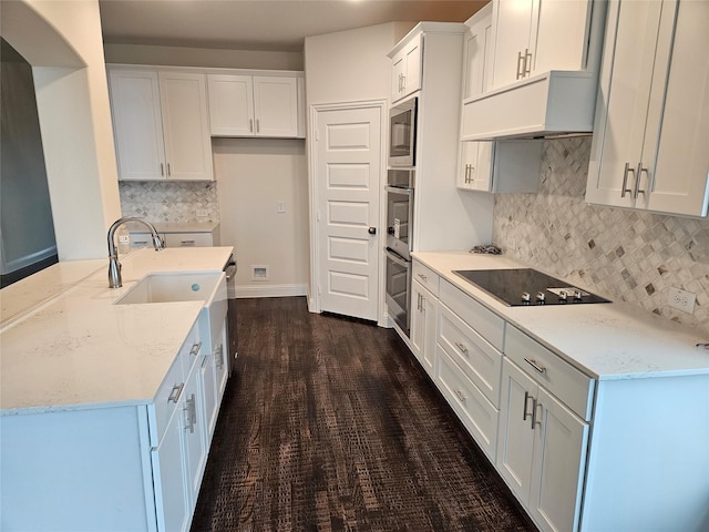 kitchen featuring built in microwave, white cabinetry, dark hardwood / wood-style flooring, light stone counters, and black electric cooktop