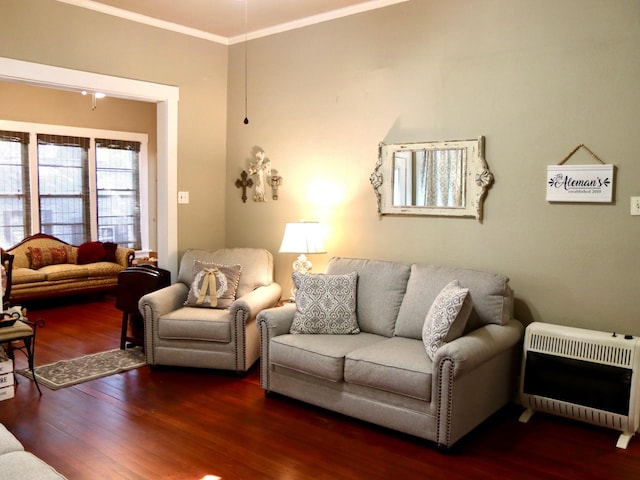 living room featuring ornamental molding, heating unit, and dark wood-type flooring