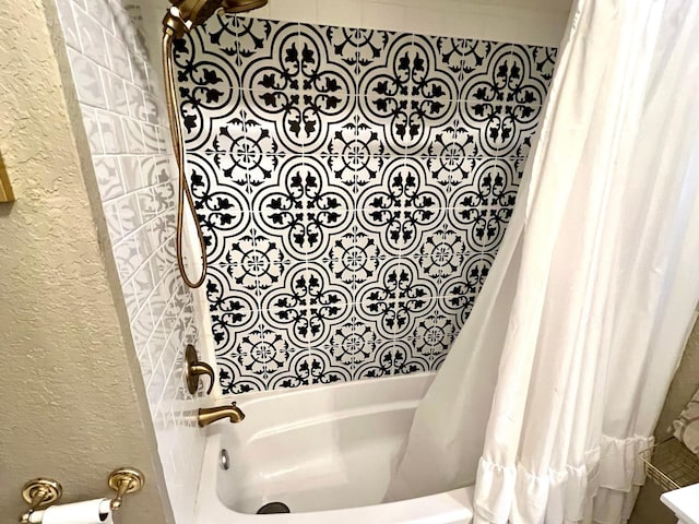 bathroom with shower / bath combo with shower curtain