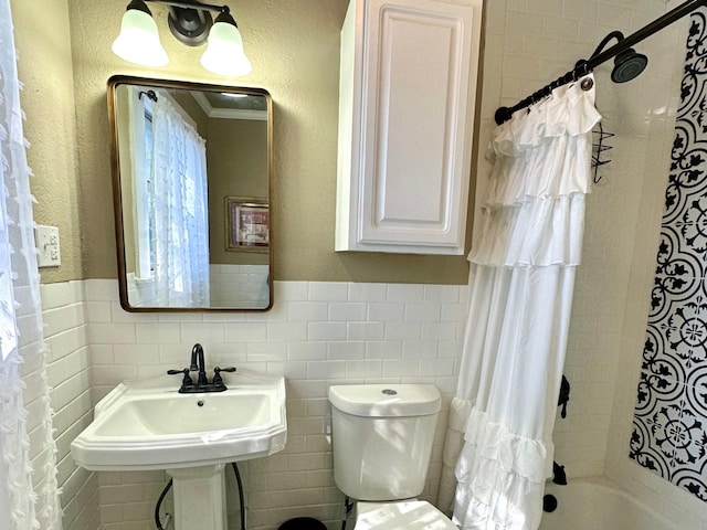 full bathroom with sink, tile walls, shower / bathtub combination with curtain, and toilet