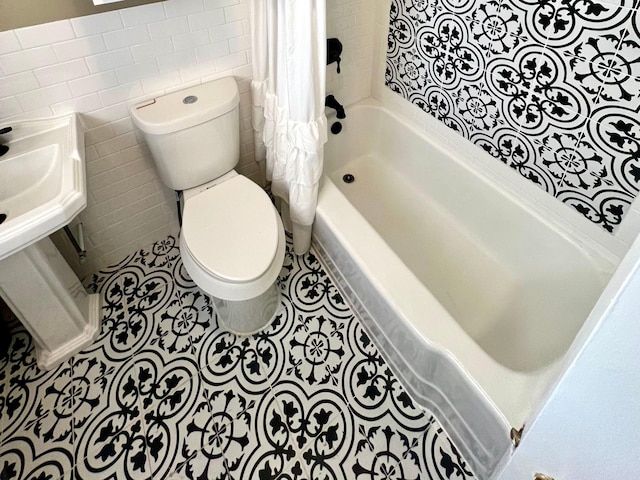 bathroom featuring shower / bath combo with shower curtain, tile patterned floors, toilet, and tile walls