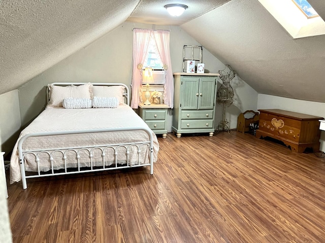 bedroom with cooling unit, hardwood / wood-style flooring, lofted ceiling with skylight, and a textured ceiling