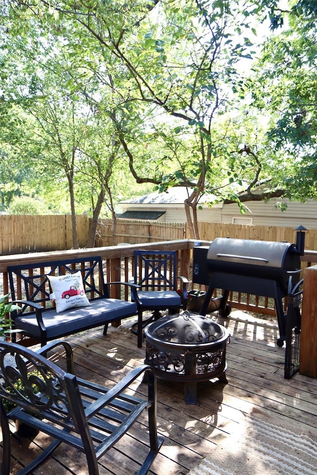 wooden terrace with area for grilling and an outdoor fire pit