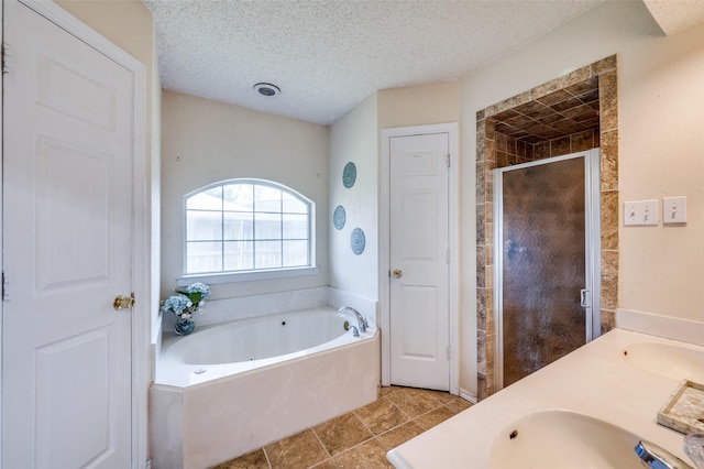 bathroom with shower with separate bathtub, vanity, and a textured ceiling