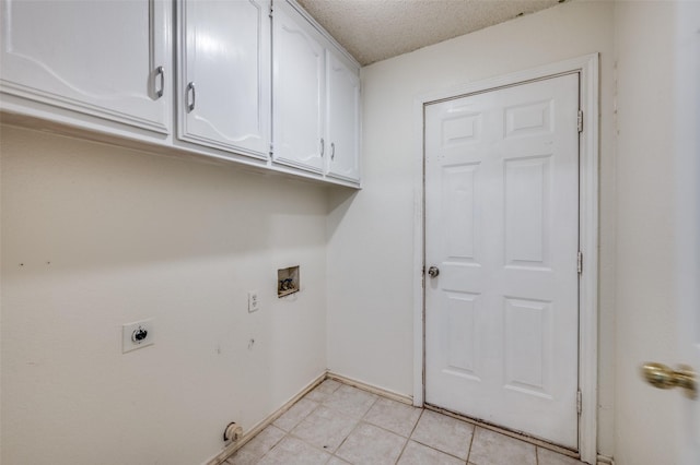 clothes washing area featuring cabinets, hookup for a washing machine, a textured ceiling, electric dryer hookup, and light tile patterned floors