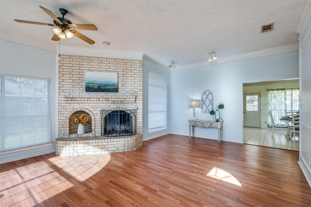 unfurnished living room featuring a healthy amount of sunlight, a fireplace, and wood-type flooring