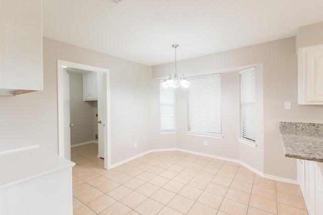 unfurnished dining area with a notable chandelier and light tile patterned flooring