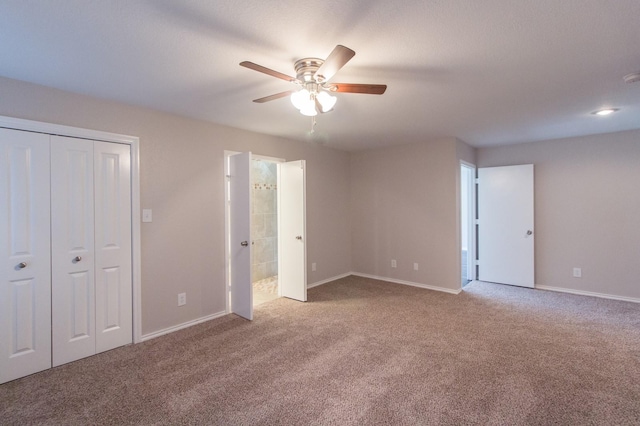 unfurnished bedroom with ensuite bath, ceiling fan, a closet, and light colored carpet