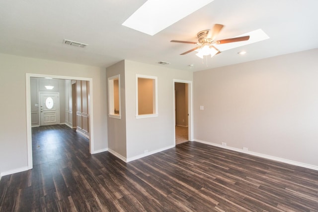 unfurnished room featuring dark hardwood / wood-style floors, ceiling fan, and a skylight