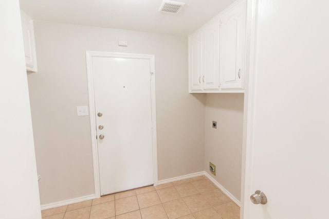 washroom with light tile patterned floors, cabinets, and hookup for an electric dryer