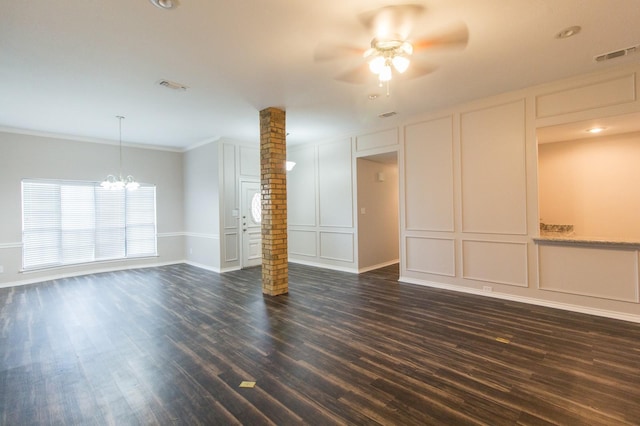 empty room featuring dark wood-type flooring, ornamental molding, ceiling fan with notable chandelier, and ornate columns