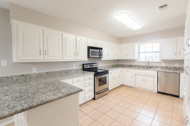 kitchen with kitchen peninsula, white cabinetry, and stainless steel appliances