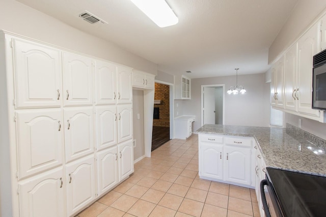 kitchen featuring white cabinets, light stone countertops, kitchen peninsula, and hanging light fixtures