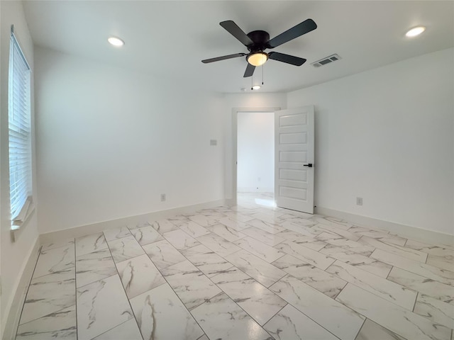 spare room with ceiling fan and a wealth of natural light