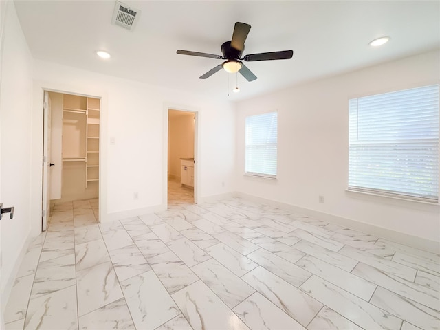 609 E 14th Ave, Corsicana, TX 75110 - unfurnished bedroom with baseboards, recessed lighting, a spacious closet, and light marble finish flooring