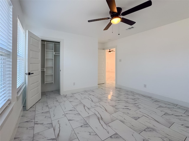 unfurnished bedroom featuring ceiling fan and a closet